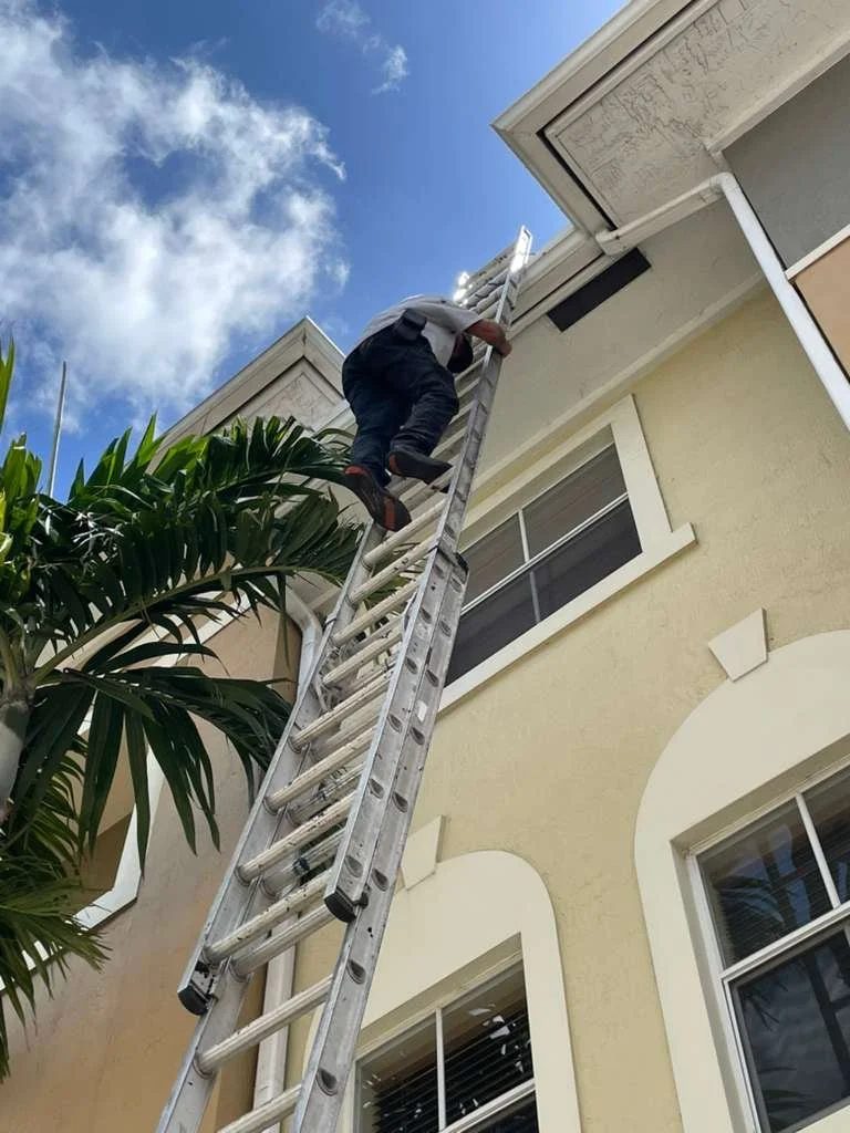 Skymen Roofing crew member climbing a ladder for a roof inspection