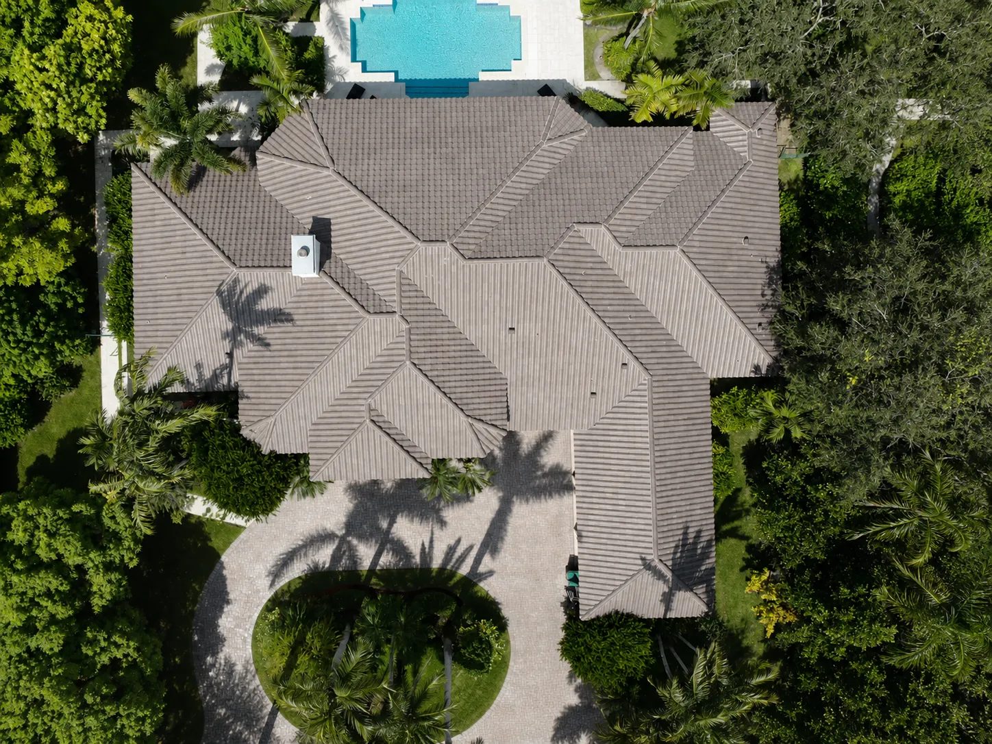 Aerial view of a gray-brown low-profile flat tile roof on a large estate home